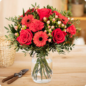 Bouquet Rubis avec roses rouges, germinis et hypéricum, rehaussé de feuillage, vu sur le comparateur de fleurs bloomyrama