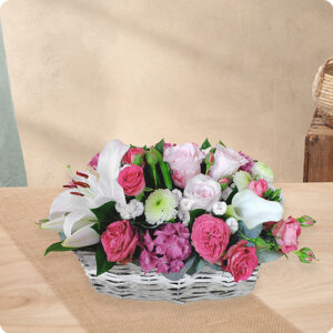 Composition Bora Bora avec fleurs de saison, roses, gerberas et lilas dans des tons rose et blanc, présentée dans une vannerie claire, vue sur bloomyrama