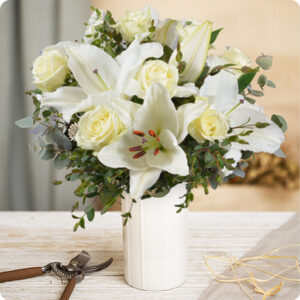 Bouquet de lys blancs et roses blanches, livré par 123fleurs avec feuillage d’eucalyptus, trouvé sur le comparateur de fleurs bloomyrama