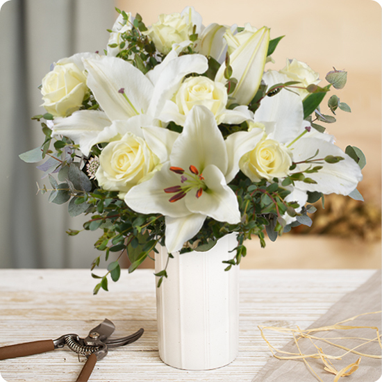 Bouquet de lys blancs et roses blanches, livré par 123fleurs avec feuillage d’eucalyptus, trouvé sur le comparateur de fleurs bloomyrama
