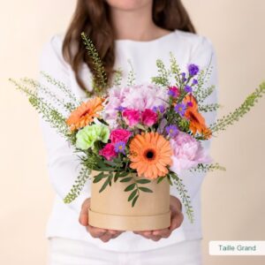 Composition florale rose et pêche avec pivoines par Interflora disponible sur le comparateur bloomyrama