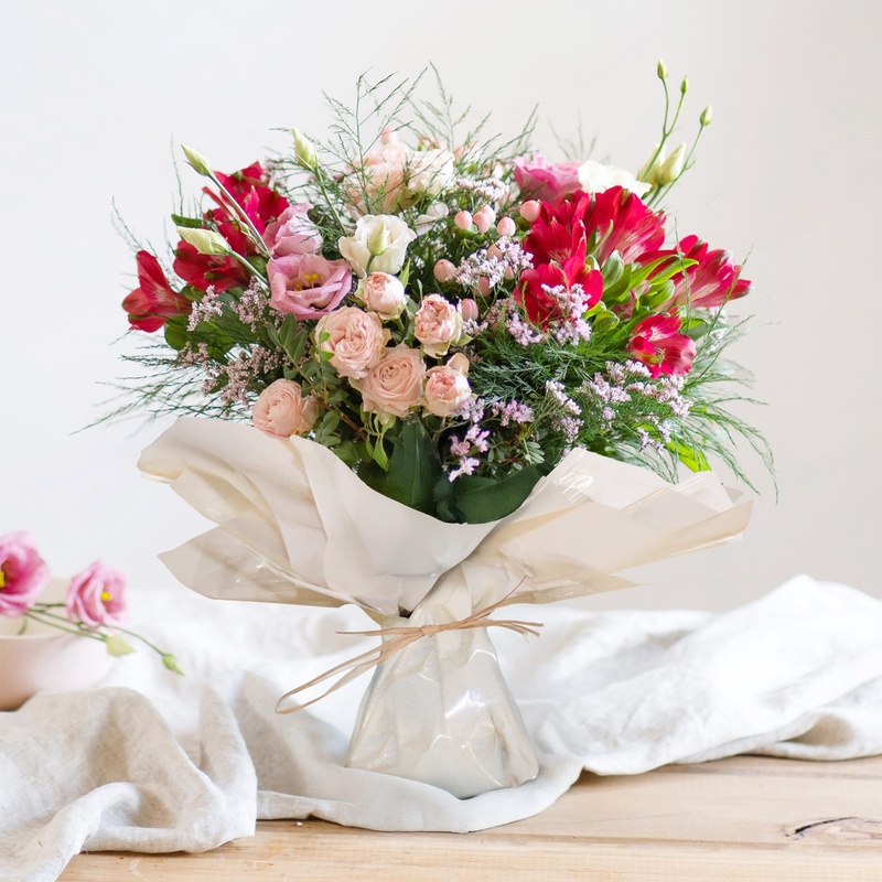 bouquet de roses lisianthus et hypericum dans des tons roses vu chez un fleuriste disponible sur le comparateur bloomyrama