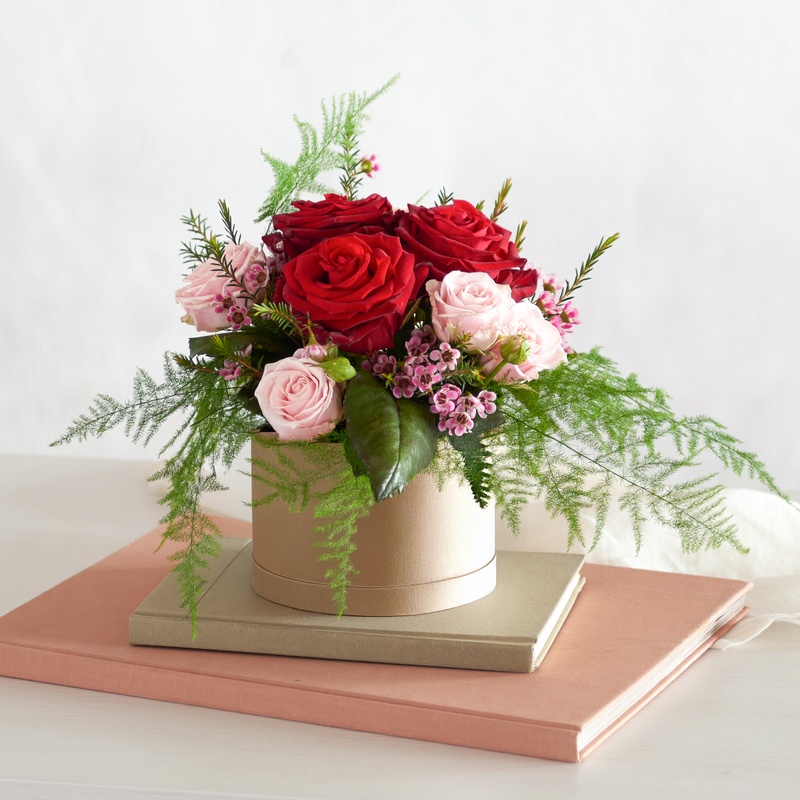 Composition florale de roses rouges et roses en boîte à chapeau élégante Interflora disponible sur le comparateur bloomyrama
