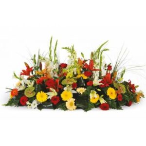 Composition de deuil colorée avec lys gerberas roses et anthuriums verts L'Agitateur Floral vu sur bloomyrama