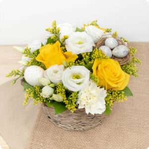 Arrangement fleuri de Pâques en vannerie avec roses jaunes 123fleurs vu sur le comparateur bloomyrama